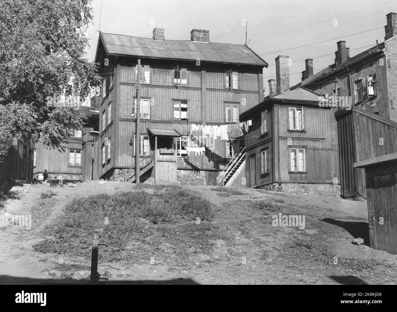 Oslo19520915 la città vecchia Enerhaugen, che è stato demolito alla fine del 50s / inizio del 60s. Ecco una foto di vecchie case di legno, lavanderia ad asciugare. Il pilastro d'acqua in primo piano. Foto: NTB / NTB Foto Stock