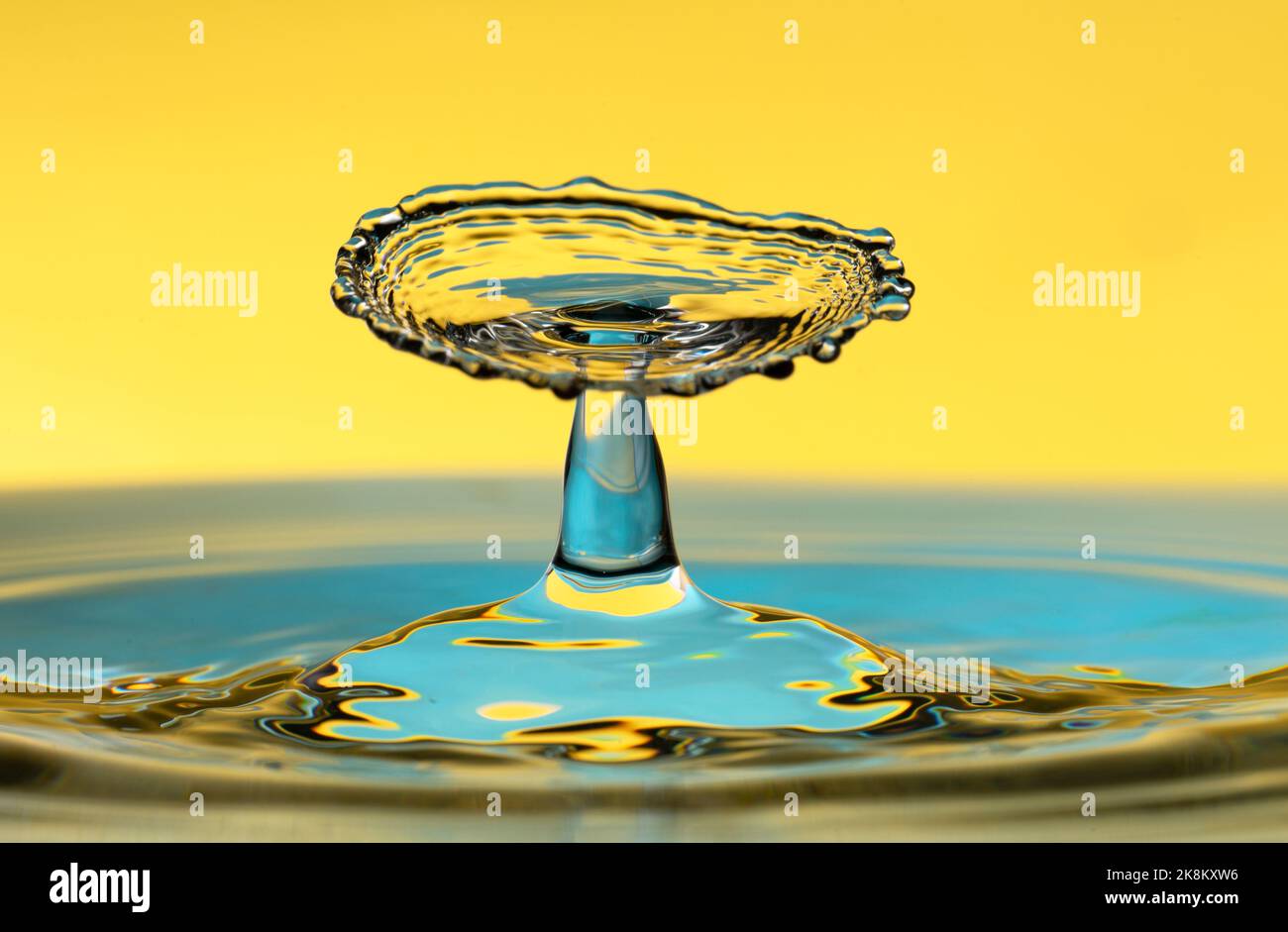 Spruzzi d'acqua isolati su sfondo giallo. Foto Stock
