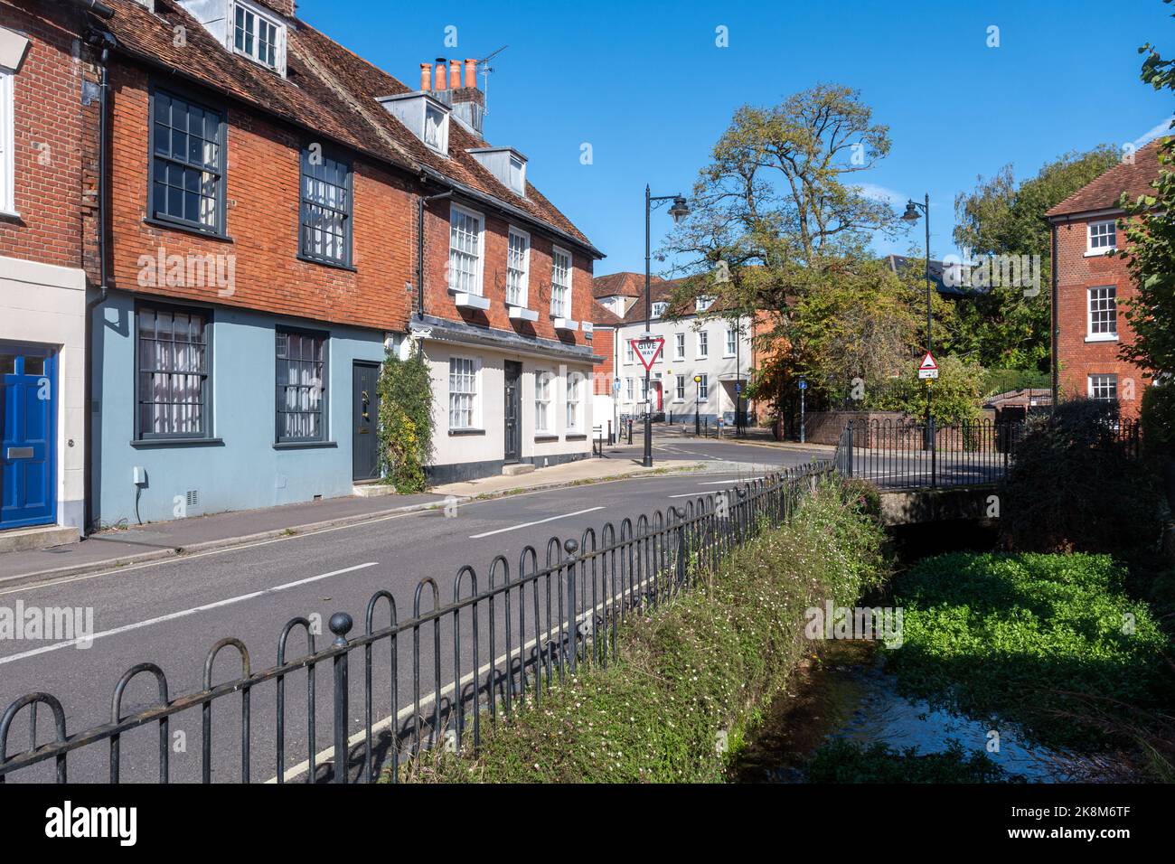 Vista di Middlebridge Street nella città di Romsey, Hampshire, Inghilterra, Regno Unito, una strada attraente con edifici storici e il torrente Holbrook Foto Stock