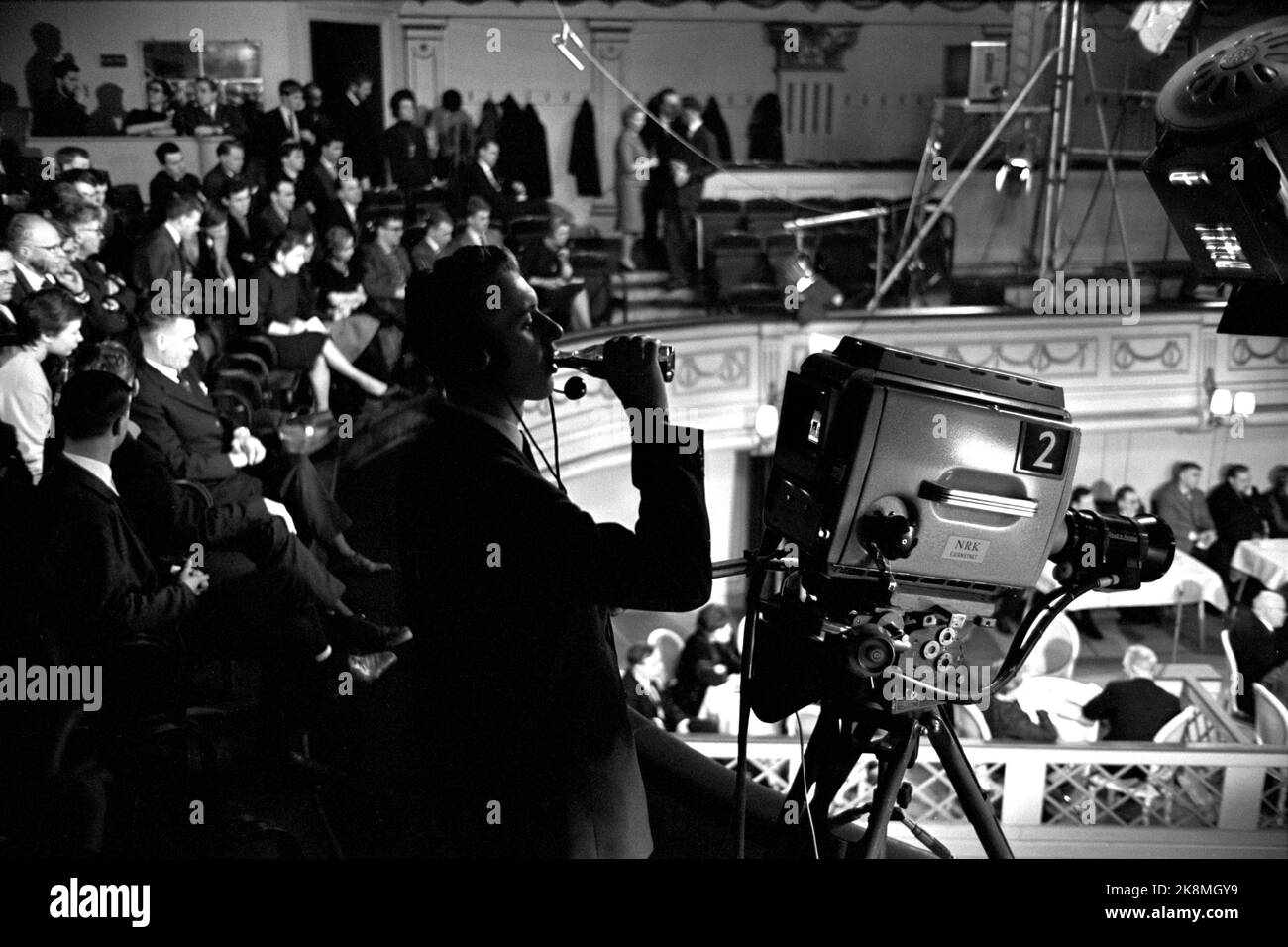 Oslo gennaio 1964 - dibattito politico televisivo al Teatro Centrale di Oslo. "Dove si trova il comunismo?" Mostra l'intero team televisivo in azione. Direttore del programma Kjell Arljot Wig. Il dibattito si svolge tra il panel e la sala. sono installate 4 telecamere e 10 microfoni. Il cameraman era assetato e prende un sorso della bottiglia. Foto: Aage Storløkken / corrente / NTB Foto Stock