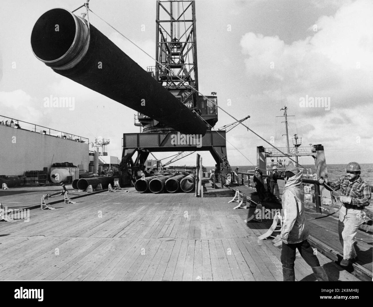Mare del Nord, 19740926: Industria petrolifera e del gas,- posa del gasdotto da Ekofisk alla EMD in Germania. I tubi lunghi 13 metri sono sollevati a bordo della nave idraulica dalla nave di alimentazione. Tre o quattro uomini hanno bisogno di tenere i tubi grandi sotto il carico della tavola. Foto NTB / NTB Foto Stock