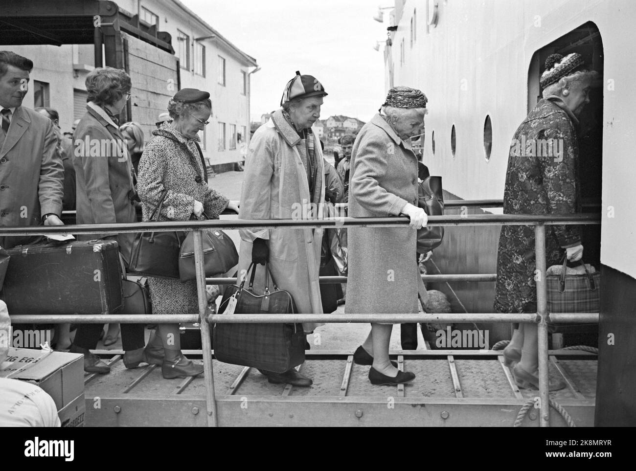 Norvegia settentrionale 19650724 turisti all'Hotel Hurtigruta turisti che vogliono vedere il più possibile la Norvegia, e il sole di mezzanotte, prendere la rotta veloce da Bergen a Kirkenes e di nuovo. Vivono in un hotel galleggiante che li porta in piccoli luoghi e città lungo la costa. Passeggeri a bordo. Donne anziane con cappello, borsa e cappotto. Turisti. Foto: Sverre A. Børretzen / corrente / NTB Foto Stock