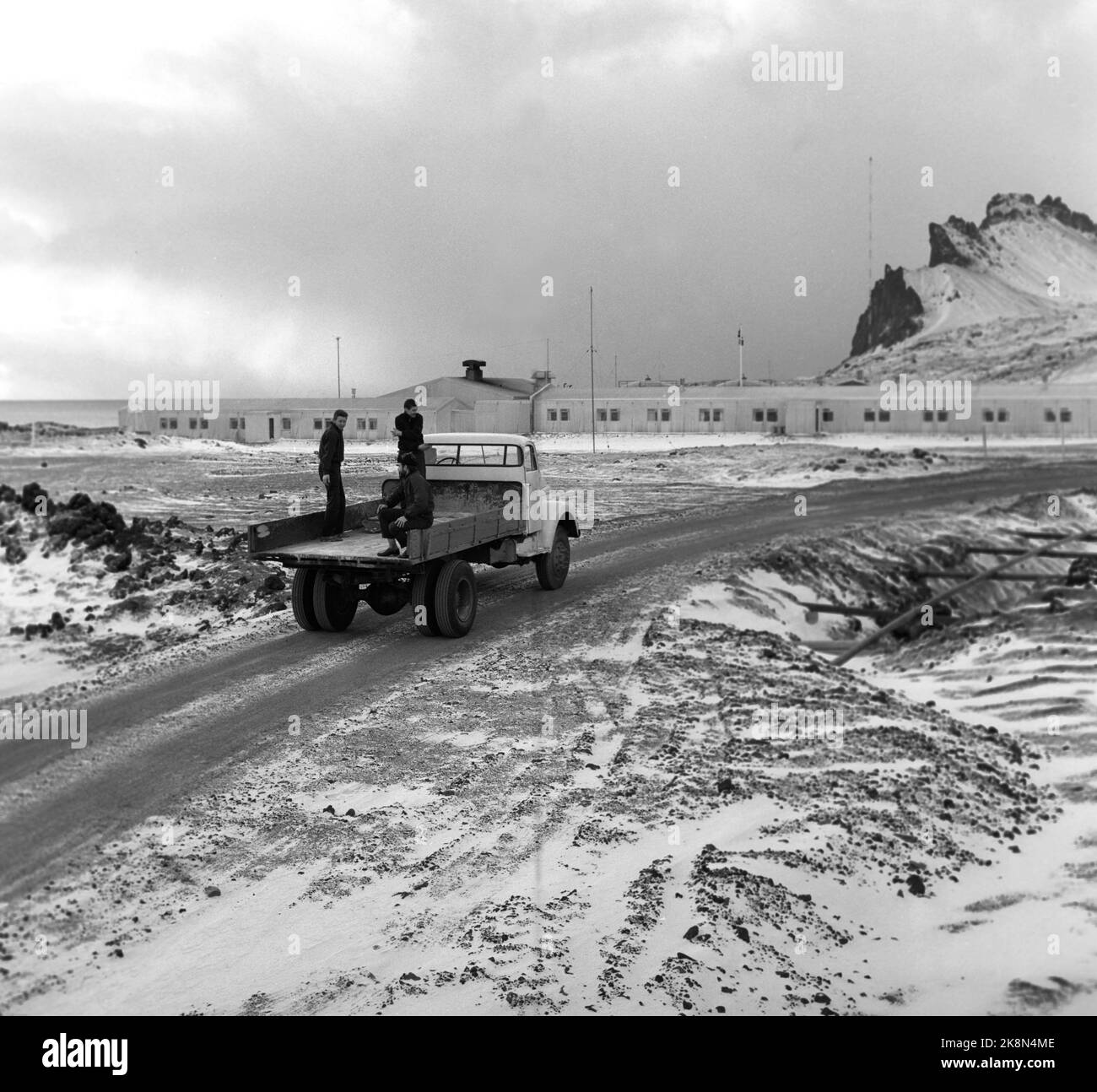 Jan Mayen 1961-11. Dalla stazione di Loran Weather Weather Weathering, dove la temperatura e le precipitazioni vengono misurate ogni 3 ore. Gli uomini sono fuori alla guida di un piccolo camion, ora che è autunno è possibile godersi il viaggio dal piano di carico. Paesaggio vulcanico su Jan Mayen. Foto: Aage Storløkken / corrente / NTB Foto Stock