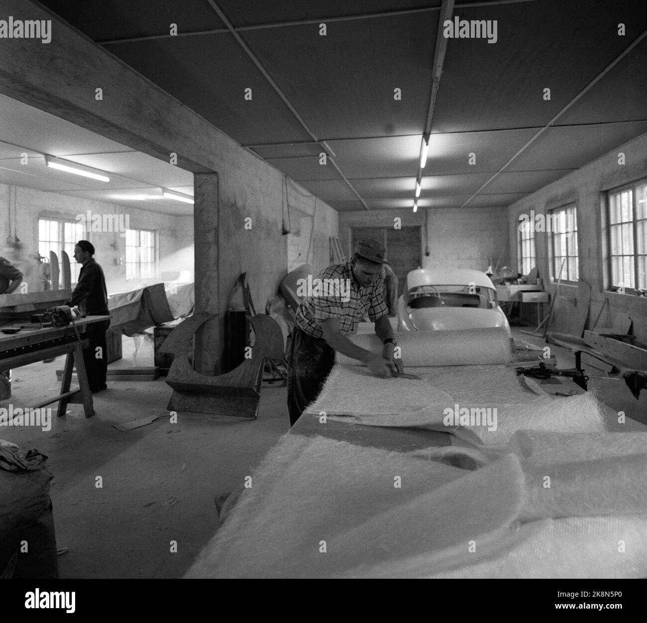 LUNDE in Telemark, 1956. Produzione del troll norvegese. Qui, i tappetini in fibra di vetro vengono tagliati, la forma viene tagliata in anticipo, con tre strati per le lastre enormi e sei strati per esempio. Le travi. Gli utensili sono comuni su misura. Foto: Sverre A. Børretzen/ NTB/ NTB Foto Stock