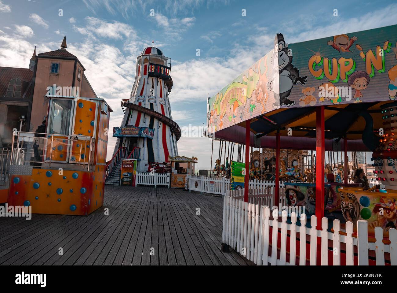 Vacanzieri sulle montagne russe e le giostre al parco divertimenti di Brighton Foto Stock