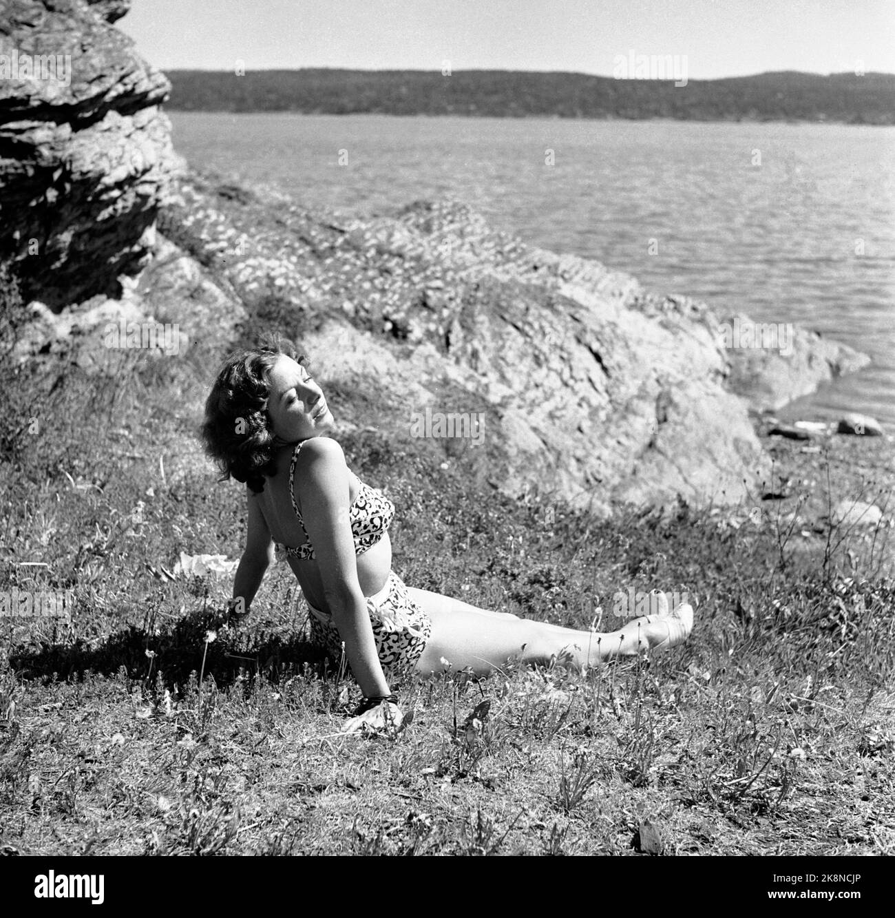 Oslo 19470601 nell'estate del 1947 fu l'estate più secca e calda nella memoria dell'uomo. La stagione balneare è iniziata a tempo record. Qui da un'area per nuotare nella zona di Oslo, dove una giovane donna in costume da bagno si bagna l'erba. Foto: NTB / NTB Foto Stock