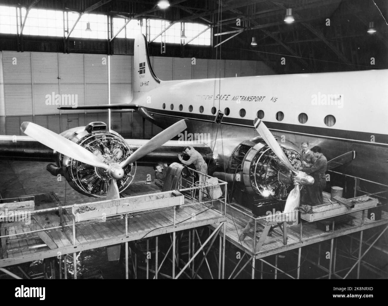 Stavanger 19531205. Braathens flyselskap, SICURO, fikk ikke ny konsesjon på Østen-ruta. HVA skal skje med verkstedet på sola? Casseforti verksted er fra 1948 bygd gradvis op til det i dag dekker 5000 kvadratmetro gulvflate, og er det eneste i Norge som tar komplett overhaling AV DC 4 (Skymaster) og det vesentligste AV selskapets Heron-fly. De ansatte er bekymret su å miste jobbene sin. Mange har stiftet familie. Nybygde hus eller leilighet som de har store lån på. Il suo ser vi fagfolkene som steller med 'Norse Skyfarer' i hangaran. Foto: Aage Storløkken / Aktuell / NTB Foto Stock