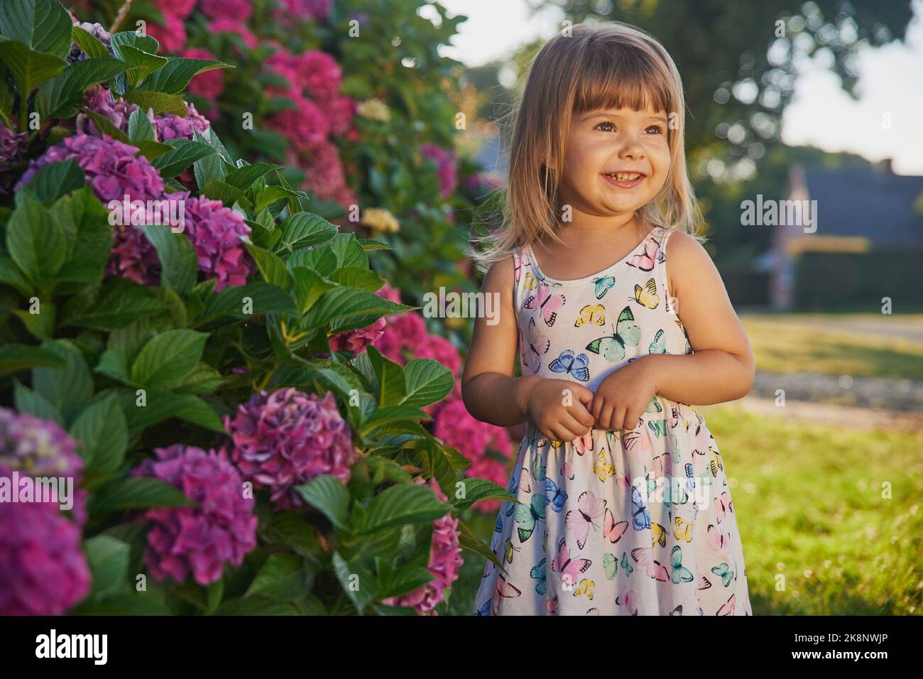 Adorabile bambino vestito come una farfalla vicino ai fiori Foto Stock