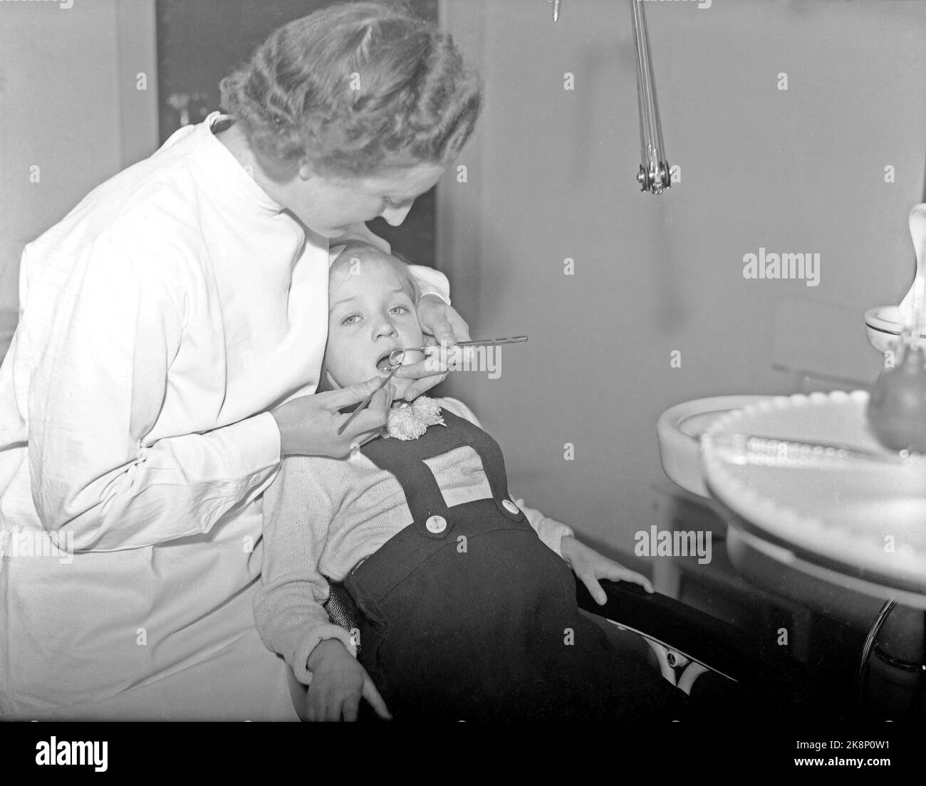 Oslo 19430319: Piccola ragazza in sedia dentale a Oslo Municipal folk tannal in Møllergata 24. Dalla lastra di vetro. Foto: Aage Kihle / NTB Foto Stock