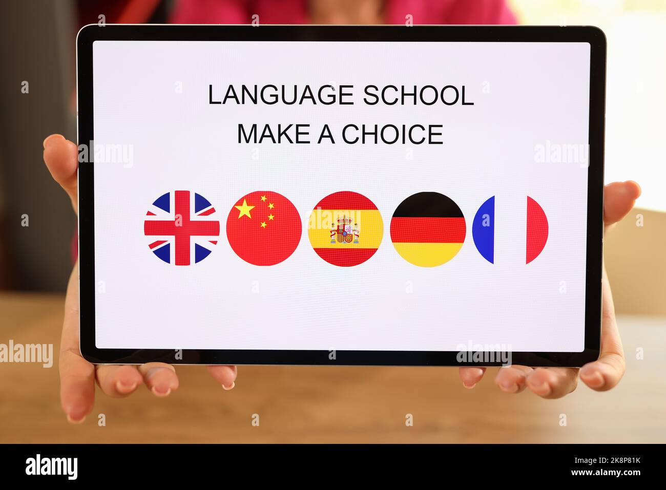 Tablet con mani femminili e applicazioni scolastiche in lingua aperta Foto Stock