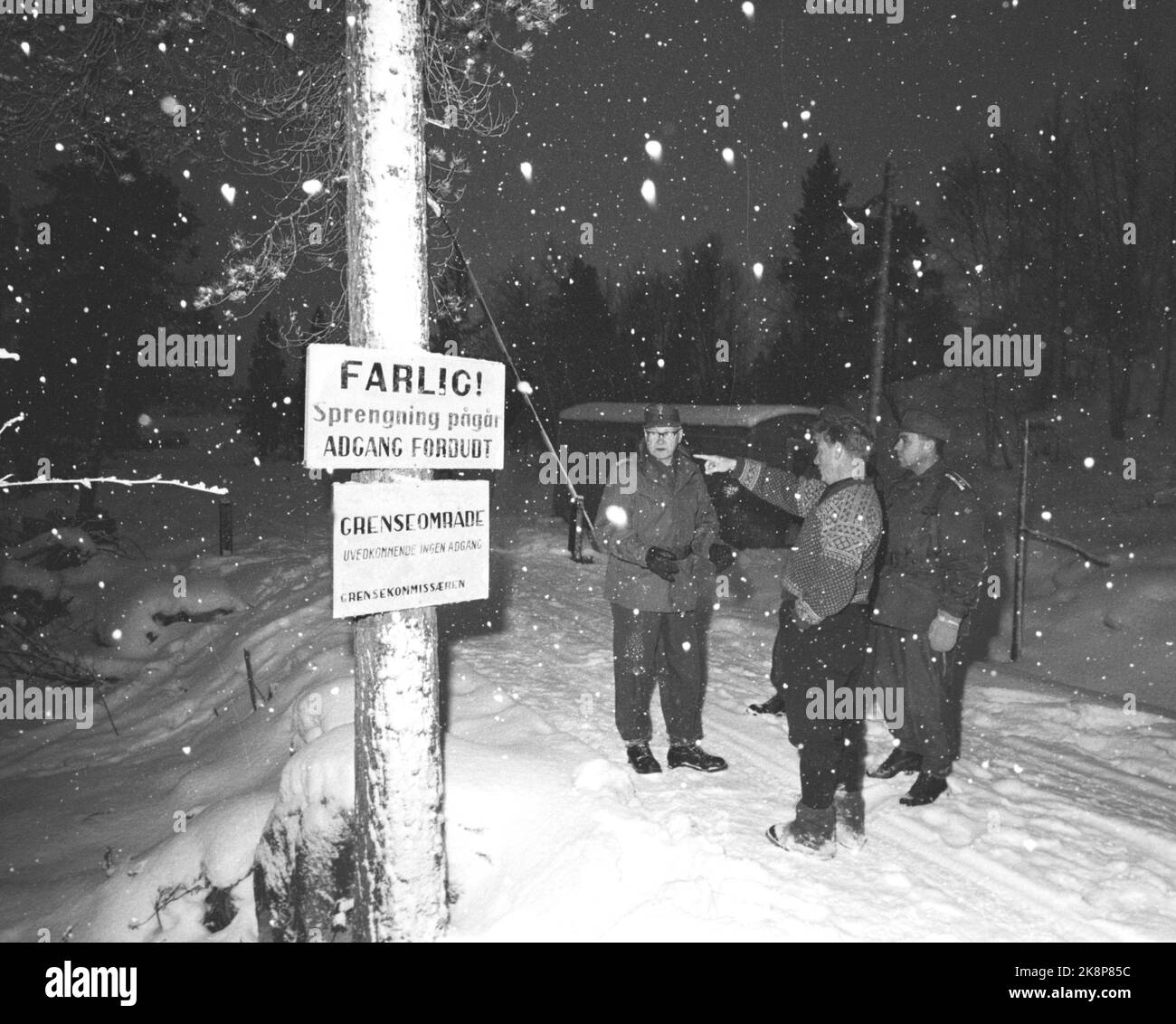 Border Jakobselv, Finmark Dicembre 1962. Il Ministro della Difesa Gudmund Harlem confina con Jakobselv con regali di Natale per i ragazzi che parlano del confine con l'Unione Sovietica. Il viaggio durò 5 giorni e divenne un viaggio duro in aereo, auto, barca e pulk. Qui, il commissario di frontiera Magnus, il ministro della Difesa Harlem (al centro) e il tenente colonnello Huifeldt, in uno dei valichi di frontiera più trafficati di Boris Gleb. I segnali sono scritti: Pericolo di brillamento in corso, accesso vietato. Area di confine. Foto: Ivar corrente di Aaserud / NTB Foto Stock