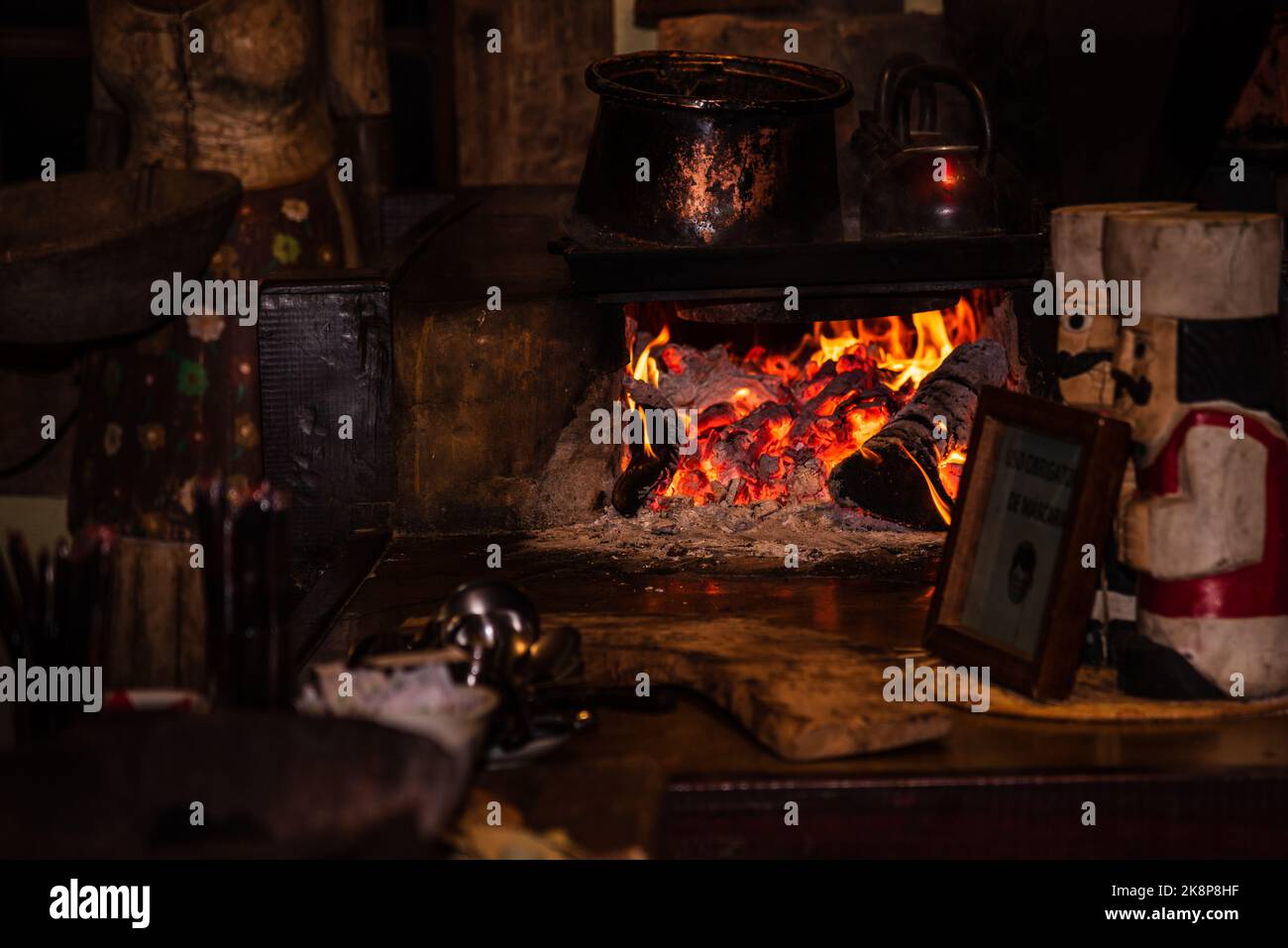 Forno a legna con fiamme in una cucina rustica scura a Minas Gerais, Brasile. Foto Stock