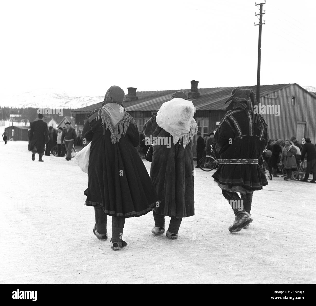 Alta, Bossekop 19520419. Bossekop- il mercato, il grande mercato famoso di Sami che si raccoglie ogni anno al Sambirkelaget in alta. Qui, ci sono molti dalle creste vicine per vendere i beni di casa, carne di renna e cuoio. Il commercio va vivace. Le merci vengono trasportate in valigie in camion da Gargia Fjellstue, che è il luogo di ritrovo per i Sami dopo che sono scesi da Vidda. Informazioni su. 40-50.000 kg. La carne viene consegnata al mercato. Qui vediamo Sami sulla strada per il mercato con sacco sul retro. Foto: Sverre A. Børretzen / corrente / NTB Foto Stock