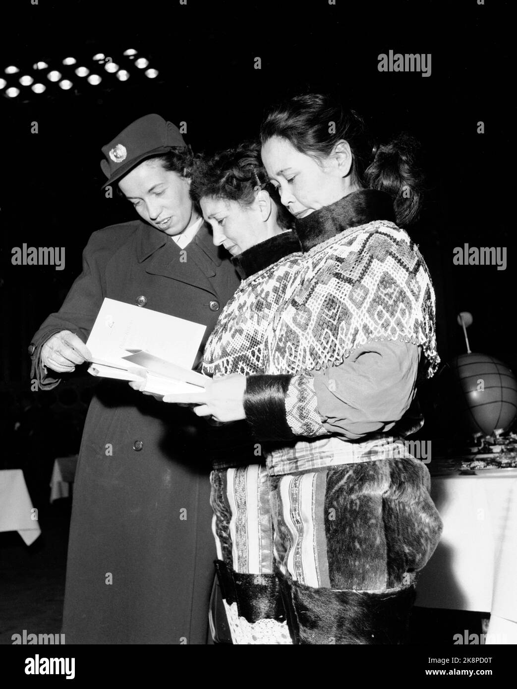 Oslo 1954115 SAS inizia la sua rotta Copenaghen / Los Angeles sul Polo Nord. Con la macchina SAS Douglas DC-6B 'Helge Viking', OY-KM. Qui, due donne studiano in costumi nazionali groenlandesi con documenti di viaggio ricamati in perle insieme ad un assistente di volo. Foto: NTB / NTB Foto Stock