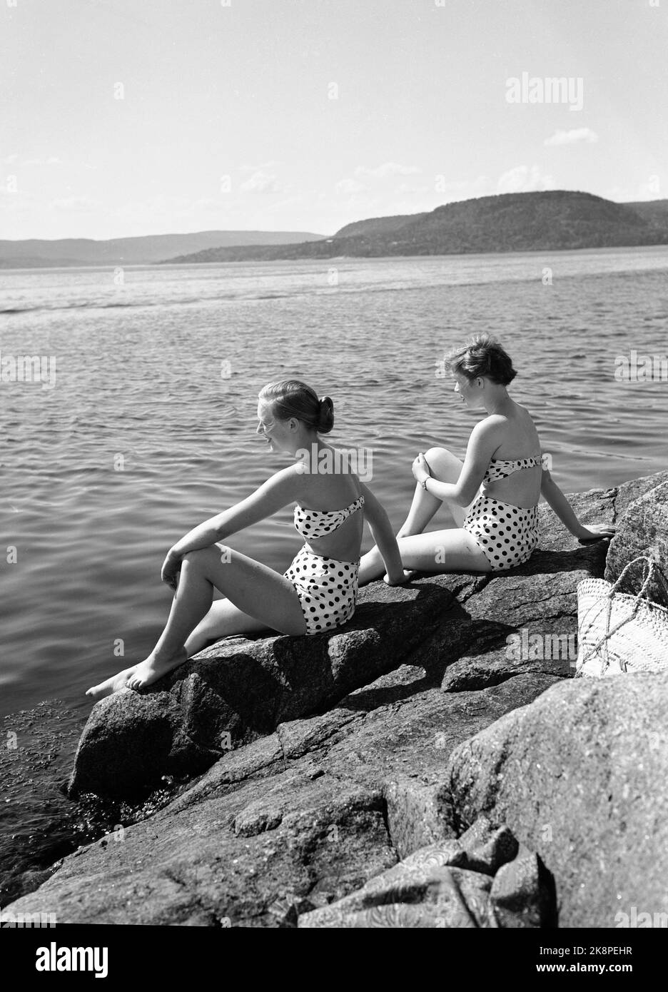 Holmsbu / Buskerud 19530614. Atmosfera estiva da Holmsbu. Vita di nuoto. Due giovani donne si crogiolano sulla montagna rocciosa, alla moda vestita di bikini punteggiati / polkadot. Vacanze estive. Foto: NTB / NTB Foto Stock