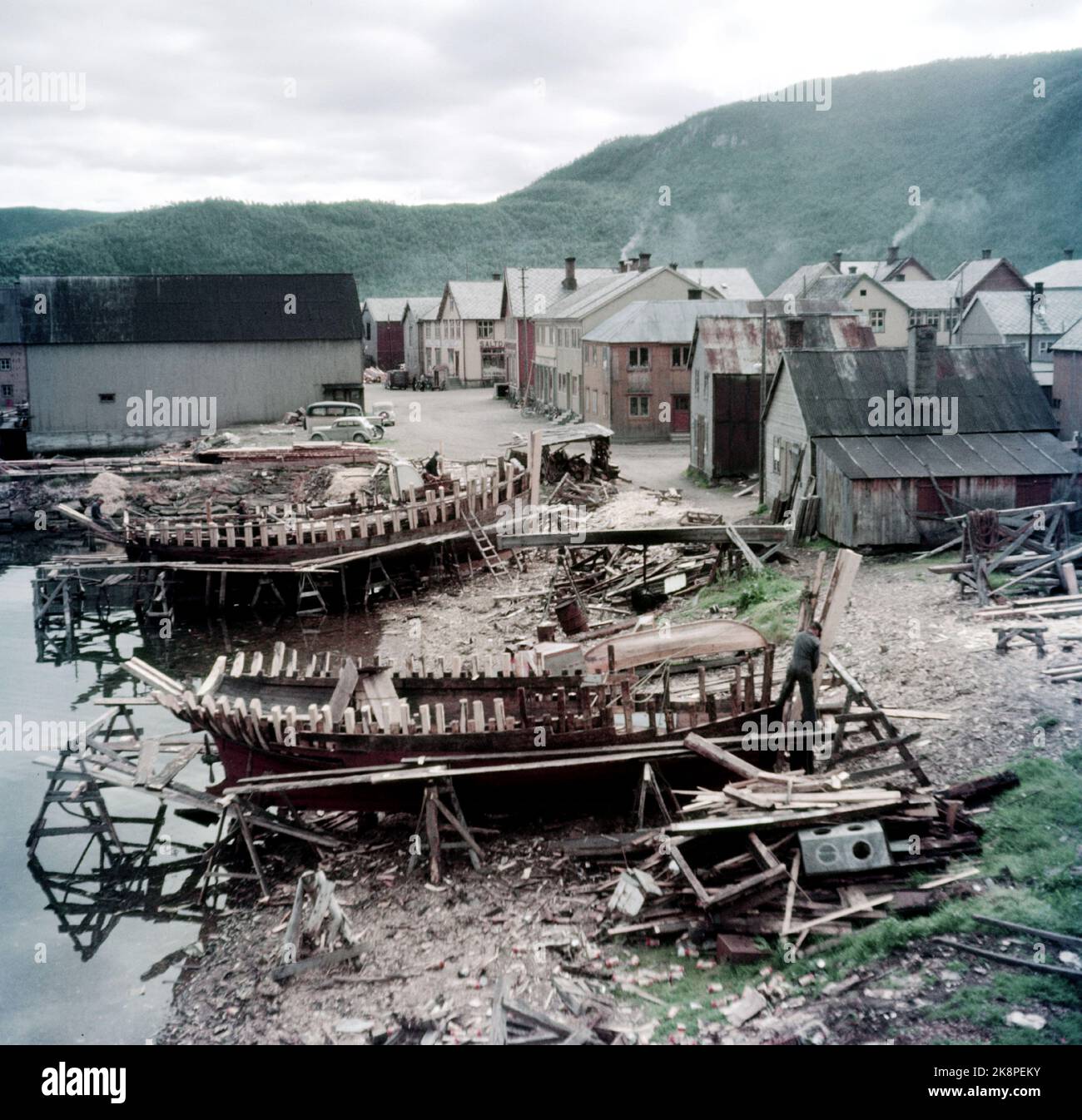 Rognan Innerst i Saltdalsfjorden 19531010. Rognan er kjent over hele Nord-Norge som stedet hvor fiskeskøyter bygges og repareres. Småskipsbyggingen har urgalle tradisjoner, per hundrevis av år siden sto folk og bygde båter i små skur nede i fjæra. De fleste bøndene har en båt for segg selv på låven i vedskjulet eller i et skur. Båtene byges i mørke høst--og vinterdager når arbeidet med gardsbruket ikke stjeler så mange timer AV døgnet. Langs hele stranda i Rognan er skøyter sotto byging eller til reparasjon. Foto: Sverre A. Børretzen / Aktuell / NTB Foto Stock