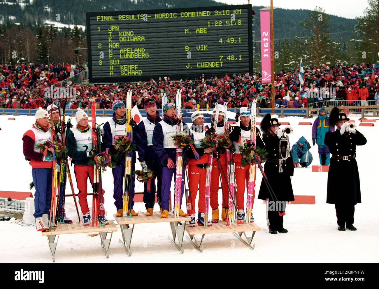 Lillehammer 19940224 Olimpiadi invernali a Lillehammer. Concorso di squadra combinato. Cerimonia dei fiori allo stadio di sci dopo la grondaia. Da v. la squadra norvegese che ha preso l'argento. Da v. Bjarte Engen Vik, Fred Børre Lundberg e Knut Tore APELY. Nel mezzo, il Giappone che ha preso l'oro. Nella squadra, T. Kono, M. Abe e K. Ogiwara. Th. La Svizzera che ha preso il bronzo. In squadra è andato H. Kempf, J.Y. Cuendez e A. Schaad. I soffiatori di tromba di sua Maestà la Guardia del Re suonano fanfares. Foto: Bjørn Sigurdsøn / NTB / NTB Foto Stock