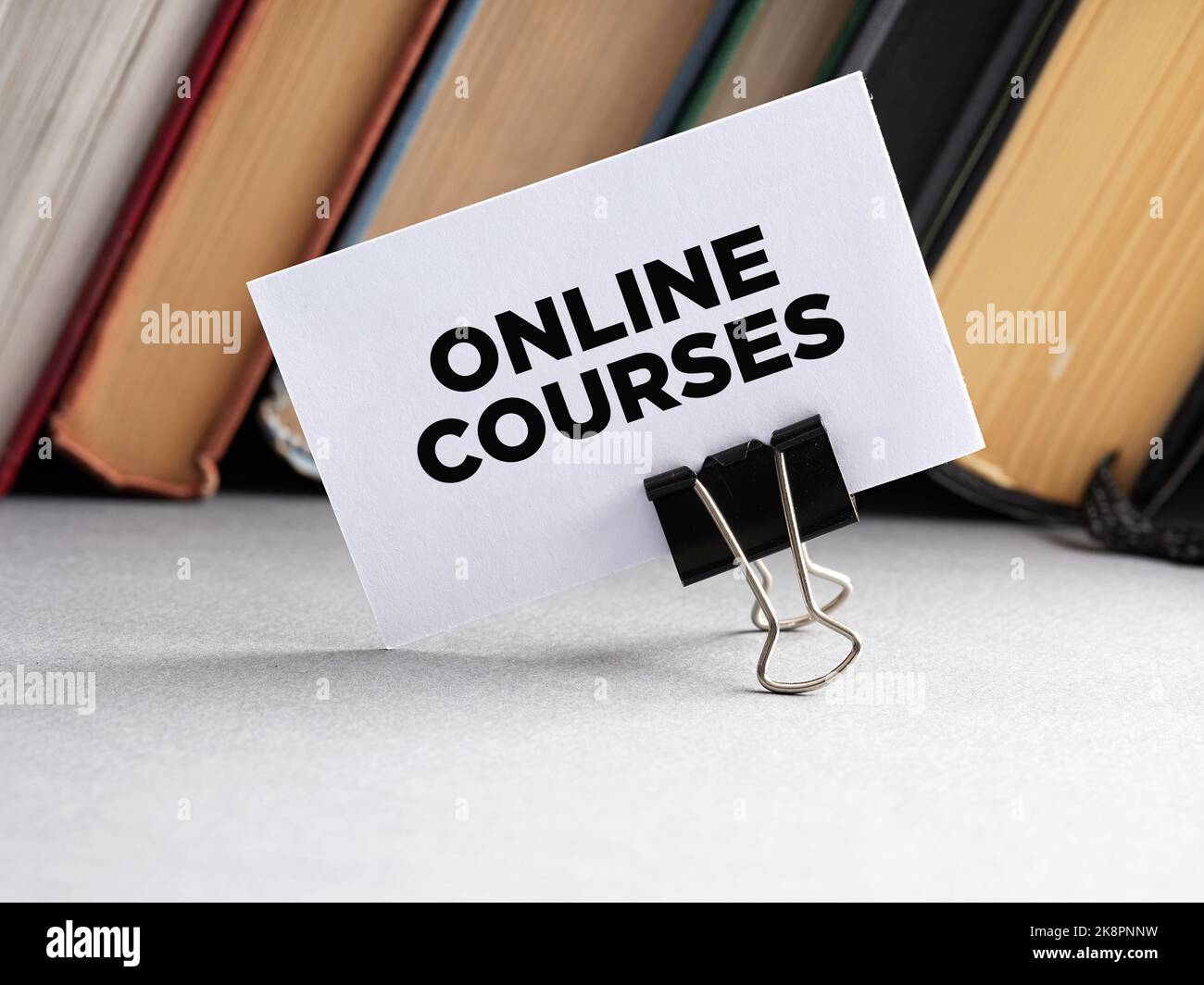 Il messaggio on-line corsi scritti su un biglietto da visita con sfondo libri. Concetto di formazione in linea. Foto Stock