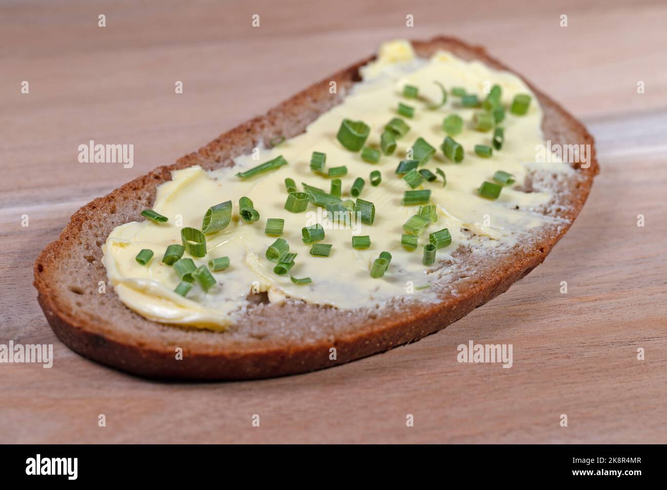 Pane imburrato con erba cipollina in un primo piano Foto Stock