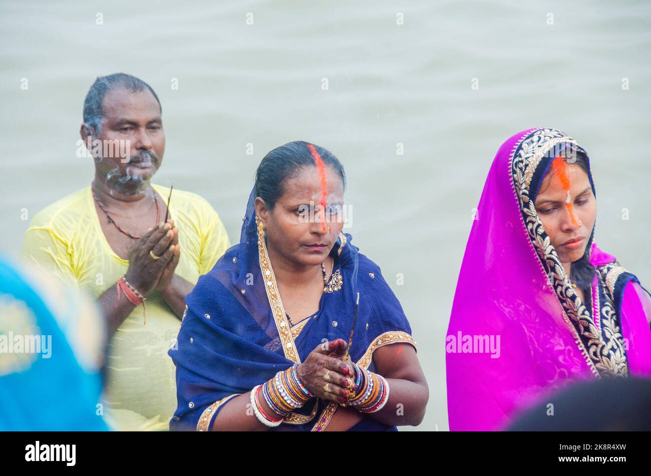 Uomini e donne indiane non identificati pregano e dedicano per il Chhath Puja festival sul lato del fiume Ganges a Varanasi, India. Foto Stock