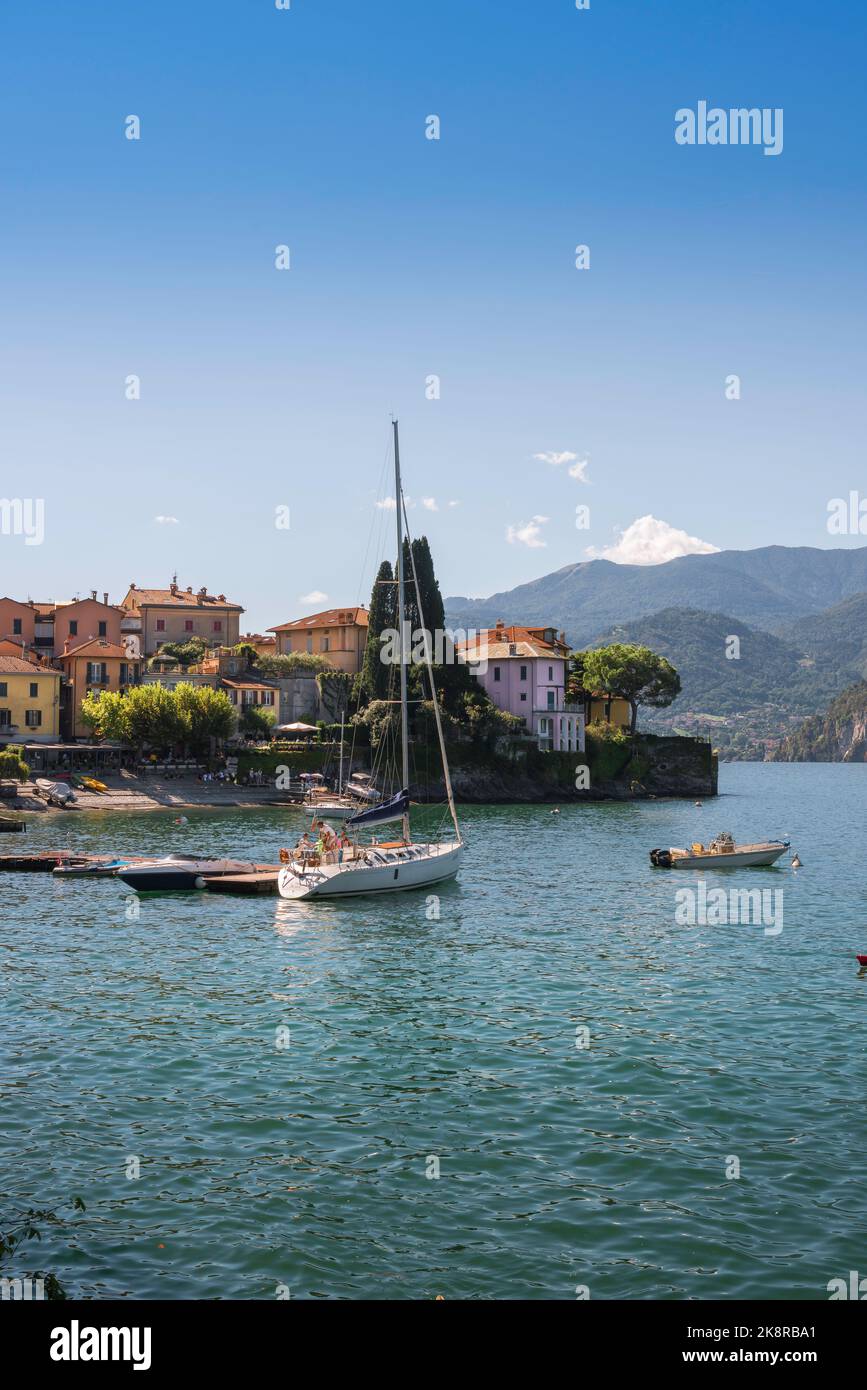 Vacanze estive sul lago, vista in estate delle barche ormeggiate nel porto della panoramica cittadina lacustre di Varenna, Lago di Como, Lombardia, Italia Foto Stock