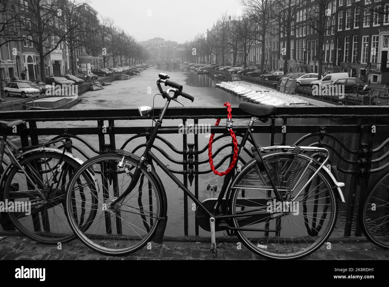 Uno scatto in bianco e nero di Bike Bridge sullo sfondo del canale di Amsterdam Foto Stock