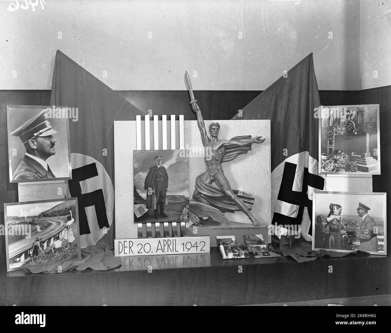 WW2 Oslo 19420418 Ufficio informazioni tedesco di Statsban, qui un modello / mostra in vetrina. "Ci 20 aprile 1942" fotografie di Adolf Hitler, autostrada e una statua di un uomo con le spade. Bandiera con croce sul mento. Foto: Kihle / NTB *** Foto non elaborata ***** Foto Stock