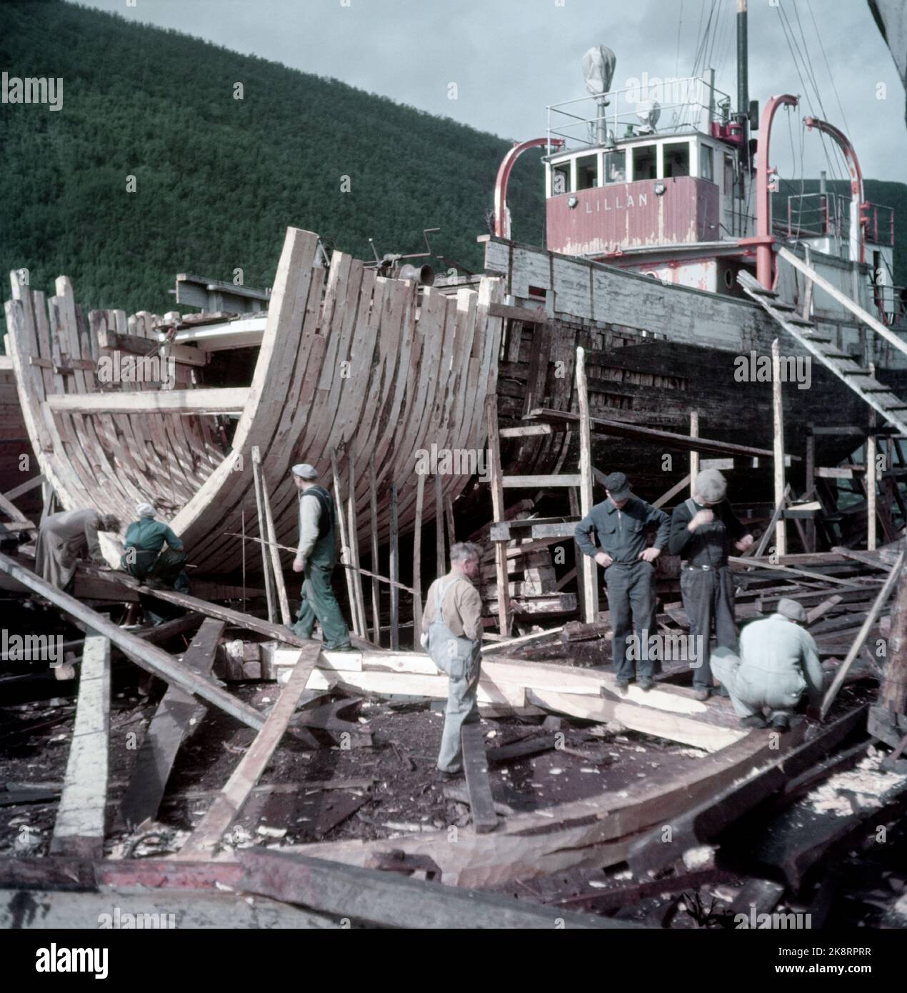 Rognan Innerst i Saltdalsfjorden 19531010. Rognan er kjent over hele Nord-Norge som stedet hvor fiskeskøyter bygges og repareres. Småskipsbyggingen har urgalle tradisjoner, per hundrevis av år siden sto folk og bygde båter i små skur nede i fjæra. De fleste bøndene har en båt for segg selv på låven i vedskjulet eller i et skur. Båtene byges i mørke høst--og vinterdager når arbeidet med gardsbruket ikke stjeler så mange timer AV døgnet. Langs hele stranda i Rognan er skøyter sotto byging eller til reparasjon. Foto: Sverre A. Børretzen / Aktuell / NTB Foto Stock