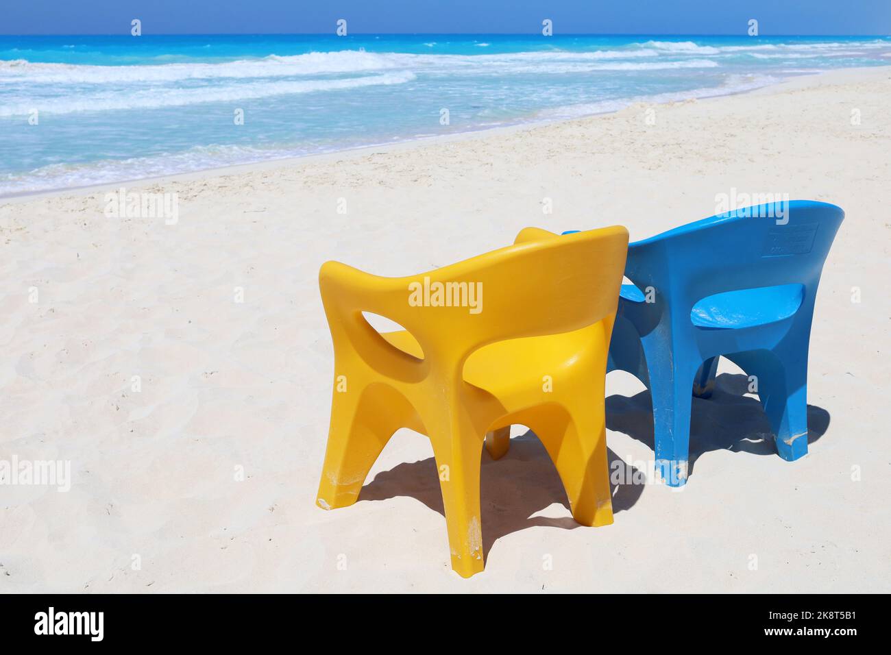 Due sedie vuote blu e giallo e spiaggia di mare paradiso, concetto di vacanza resort, colori ucraini, silenziosa costa nord ad Alessandria, Egitto Foto Stock