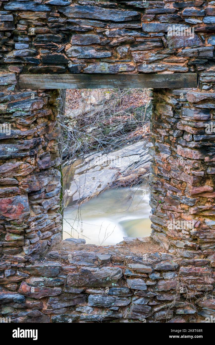 Un colpo verticale del torrente di corda da una finestra rovinata della cartiera Foto Stock