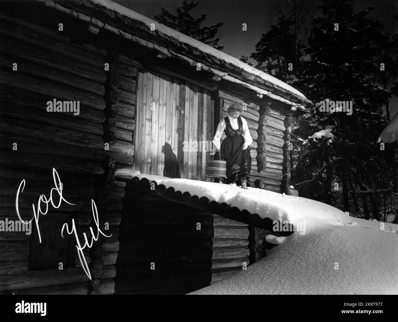 Oslo Natale 1960 Buon Natale. Donna in bunad fuori della porta del fienile. Natale, bunad, foto di illustrazione, nostalgia Foto: NTB / NTB Foto Stock