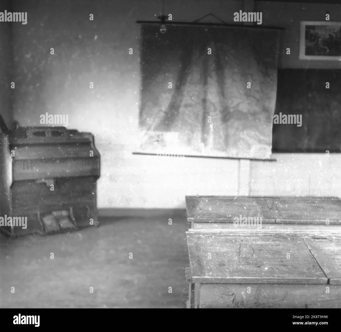 Lofoten, inverno 1951. Diversi villaggi di pescatori a Lofoten sono abbandonati perché sono impossibili da operare senza elettricità, strada, banchina e connessione telefonica. In alcuni luoghi, i comuni hanno chiesto di spostare denaro dallo stato per spostare le case e l'intera popolazione. Qui gli interni dell'edificio scolastico abbandonato di Helle, fotografati attraverso una finestra. La mappa europea è ancora in sospeso, e in un angolo c'è un organo di casa. Foto: Sverre A. Børretzen / corrente / NTB Foto Stock