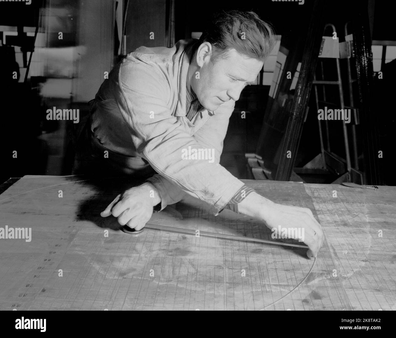 Drammen 19470122 interni da Glassverket in Drammen. Uomo che taglia una lastra di vetro rotonda con un tagliavetro. Foto: NTB / NTB Foto Stock