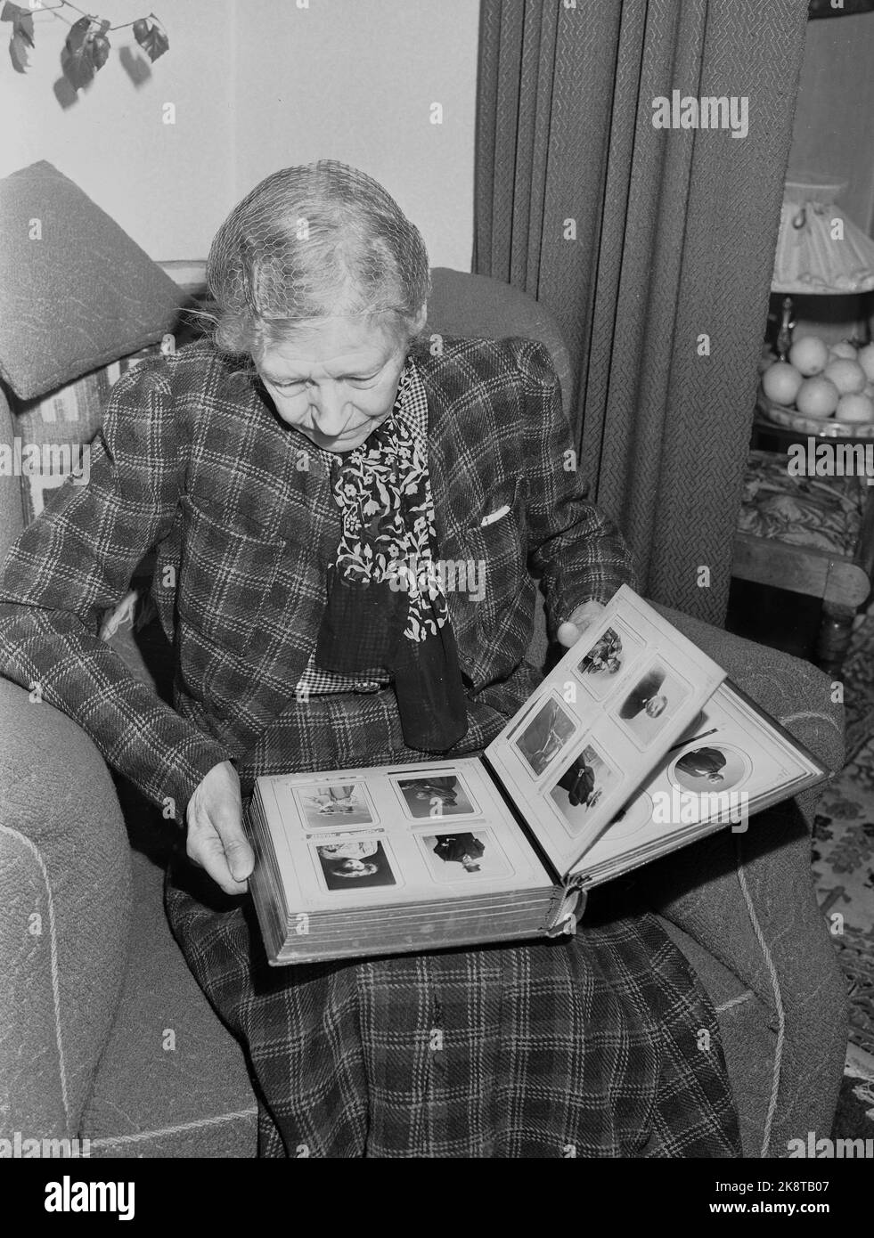 Oslo 19530122. La vecchia signora con le reti dei capelli guarda in album. Foto: Archivio NTB / NTB Foto Stock