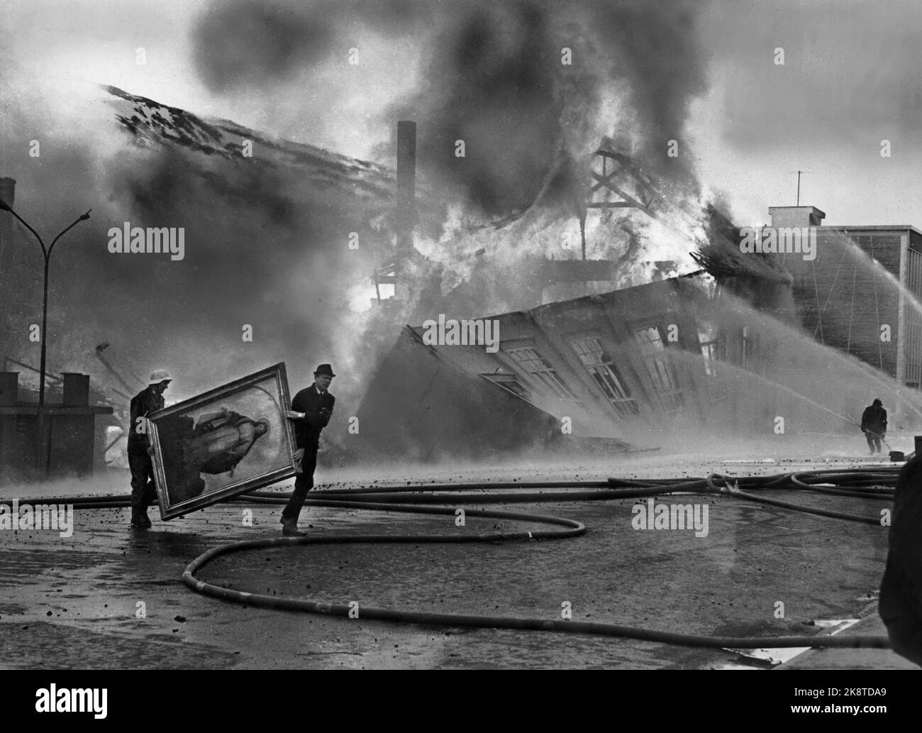 Tromsø 196905 fuoco della città a Tromsø, il più grande incendio della storia della città. Gli equipaggi di rilievo cercano di salvare i valori. Due membri della congregazione cattolica hanno fatto un'immagine della Madonna, mentre i locali dell'Associazione dei lavoratori sono crollati nelle fiamme. Foto: Karl Arvid Roman jr. / Corrente / ntb Foto Stock