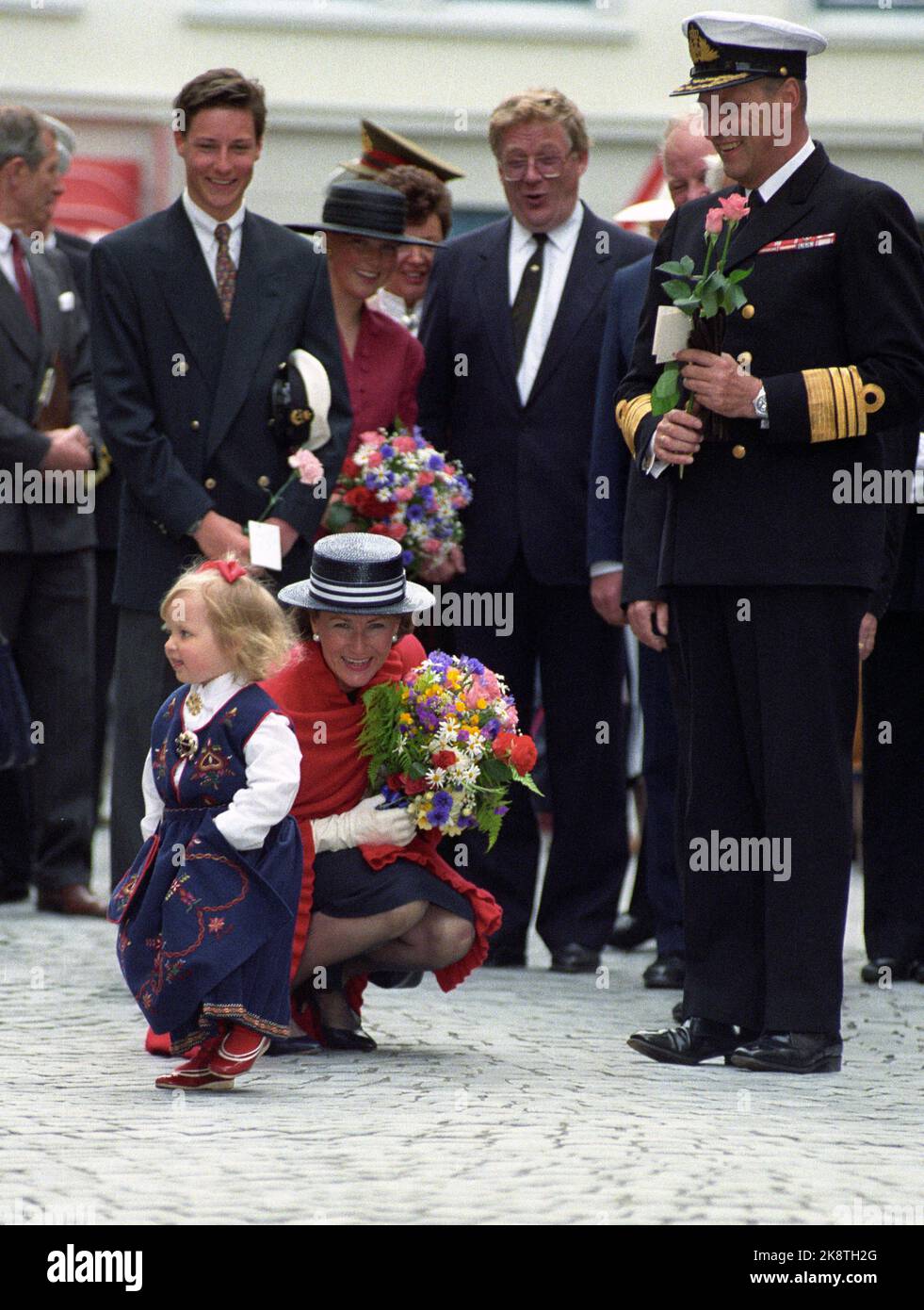 Ålesund 19910624: Siggingferden giugno 1991. Re Harald V - Firma e Signinger. La foto: Camilla Berge di tre anni scava dopo aver dato alla regina Sonja un piccolo bouquet di fiori durante la visita a Ålesund. Sullo sfondo anche f.v. Il principe ereditario Haakon, la principessa Märtha Louise, il sindaco della contea Lars Ramstad e il re Harald. - Coppia King - Foto: Bjørn Sigurdsøn / NTB / NTB Foto Stock