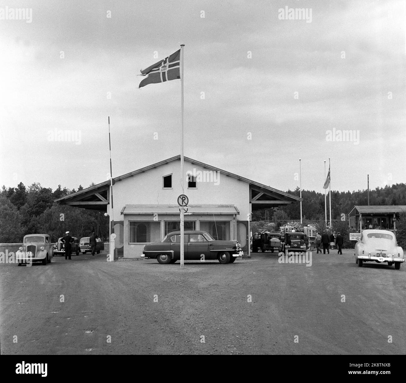 Svinesund, 19530908. La nuova stazione doganale di Svinesund. Autobus e auto sono in attesa di passare sulla strada sterrata. Edificio semplice con baldacchino. Notate l'auto sulla destra che ha i cartelli per gli Stati Uniti. Foto: NTB Foto Stock