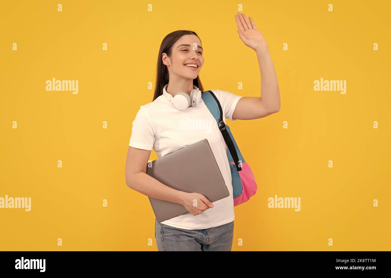 signora felice in cuffie tenere pc portare zaino, ciao Foto Stock