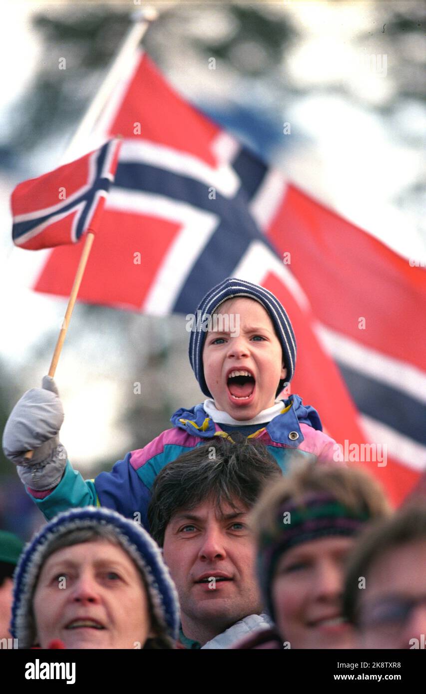 Holmenkollen Oslo. 19920315. Il 100th° anniversario di Holmenkollbakken. Informazioni su. erano presenti 75.000 spettatori. Marius Nilsen di 6 anni con bandiera ha il ruggito Kollen all'interno. Papà Bjørn ha una presa solida intorno alle gambe sul suo figlio entusiasta. La prima volta che questa arena era in uso per la corsa di Holmenkoll era nel 1892. Foto: Gorm Kallestad NTB / NTB Foto Stock