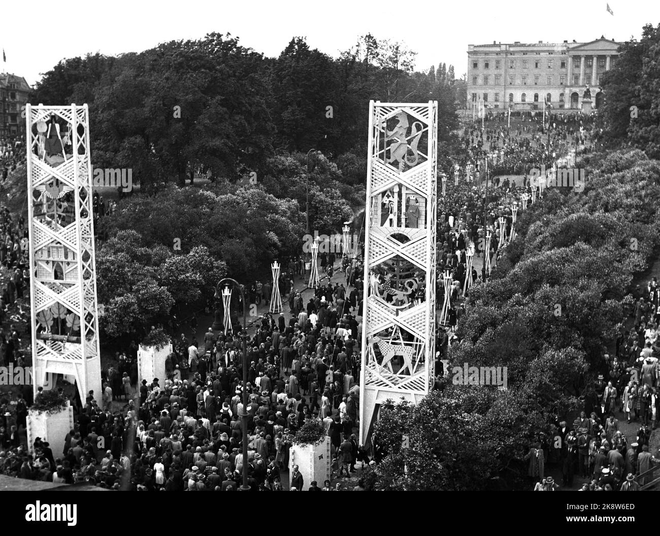 Oslo 19450607: Giornate della pace 1945 Una folla esultante ha accolto la famiglia reale in Norvegia il 7 giugno 1945. Ecco una panoramica della porta di Karl Johans che mostra migliaia di persone in viaggio verso il castello. Colonne alte con i.. Le armi nazionali sono state erette come portali fino al castello. Foto: NTB / NTB cartella NTB: Royal. Foto Stock