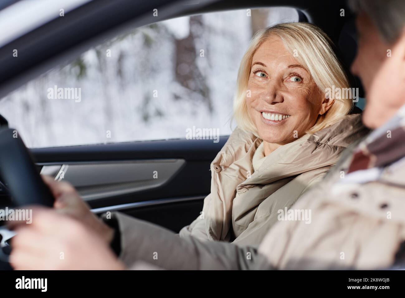 Ritratto di donna matura sorridente che si diverte in auto con il marito in inverno Foto Stock