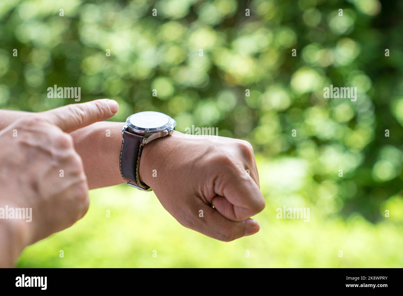 L'uomo punta il dito verso l'orologio. È tempo o concetto di fretta. Foto Stock