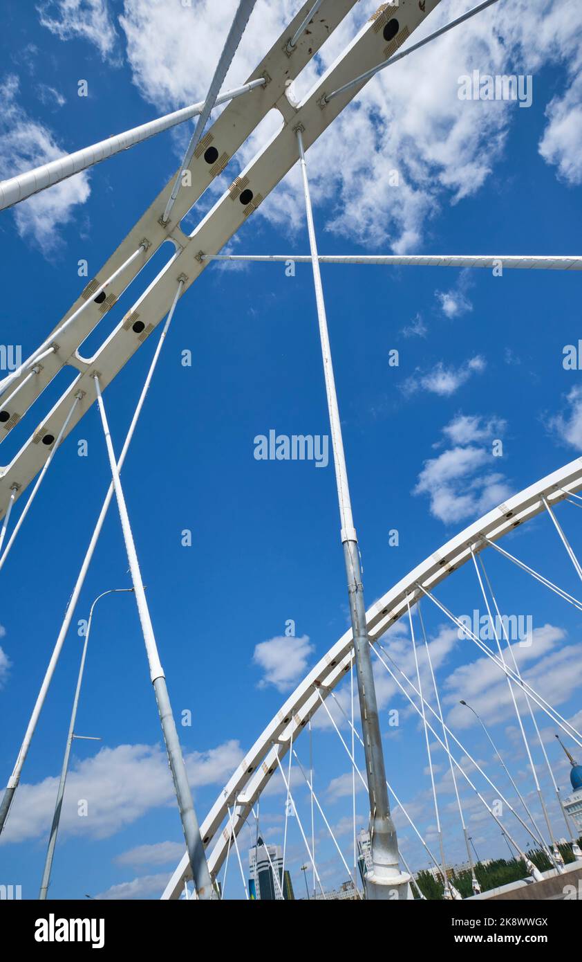 Sguardo astratto e grafico agli archi bianchi, alle curve e ai cavi del ponte sospeso del ponte di via Sganak sul fiume Ishim. Ad Astana, N. Foto Stock