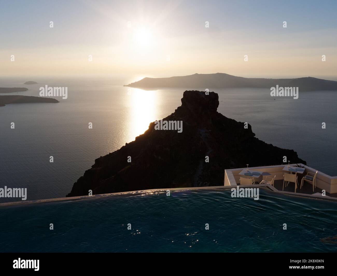 Tramonto sulla Thirasia con Skaros Rock in primo piano. Isole Cicladi dell'Egeo Isola di Santorini, Grecia. Foto Stock