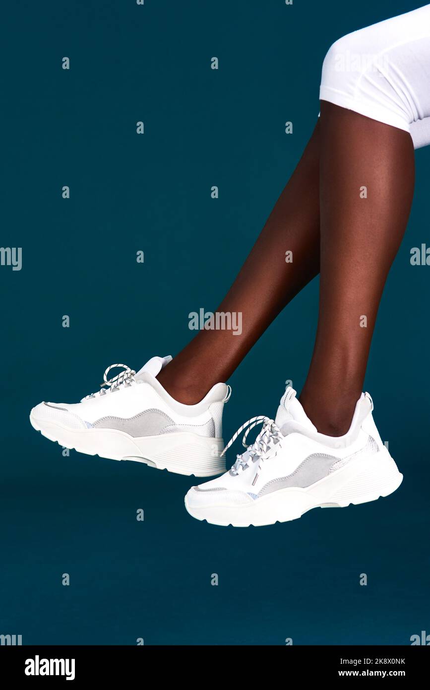 Nuove sneakers mi danno una nuova motivazione. Uno sportivo irriconoscibile che indossa le sneakers prima di allenarsi su uno sfondo scuro in studio. Foto Stock