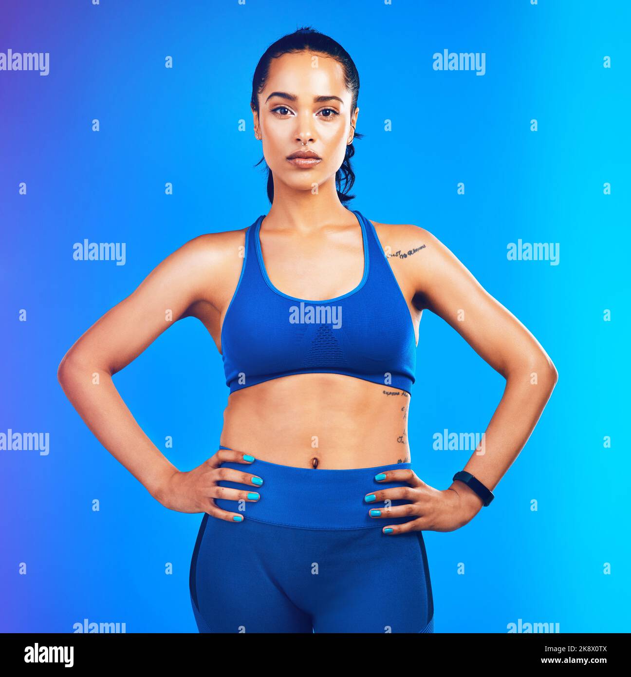 Renda il vostro corpo più forte delle vostre scuse. Studio ritratto di un giovane sportivo attraente posa con le mani sui fianchi contro un blu Foto Stock