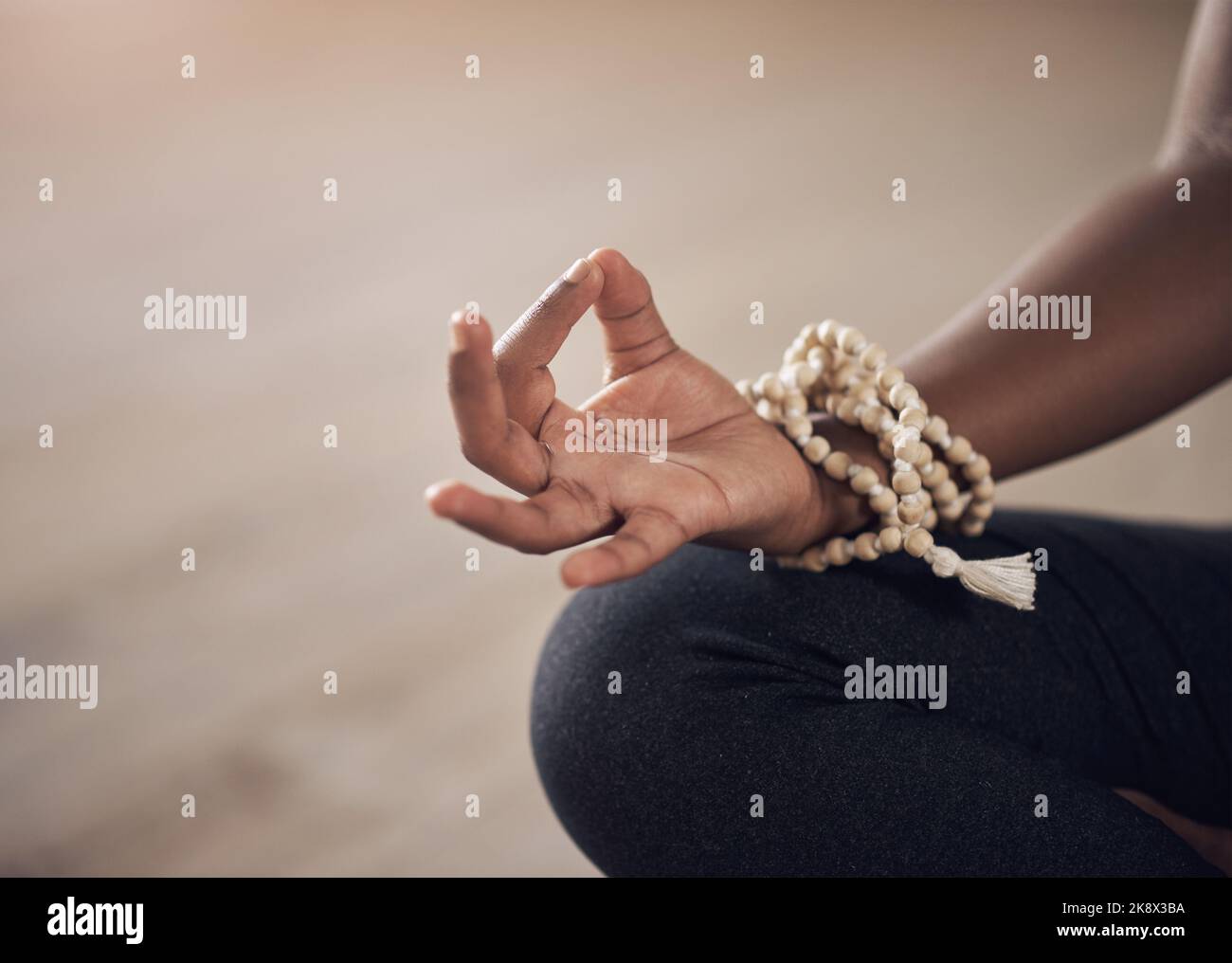 La pace viene dall'interno. Una donna irriconoscibile seduta in casa da sola e meditante con la mano in una mudra gyan. Foto Stock