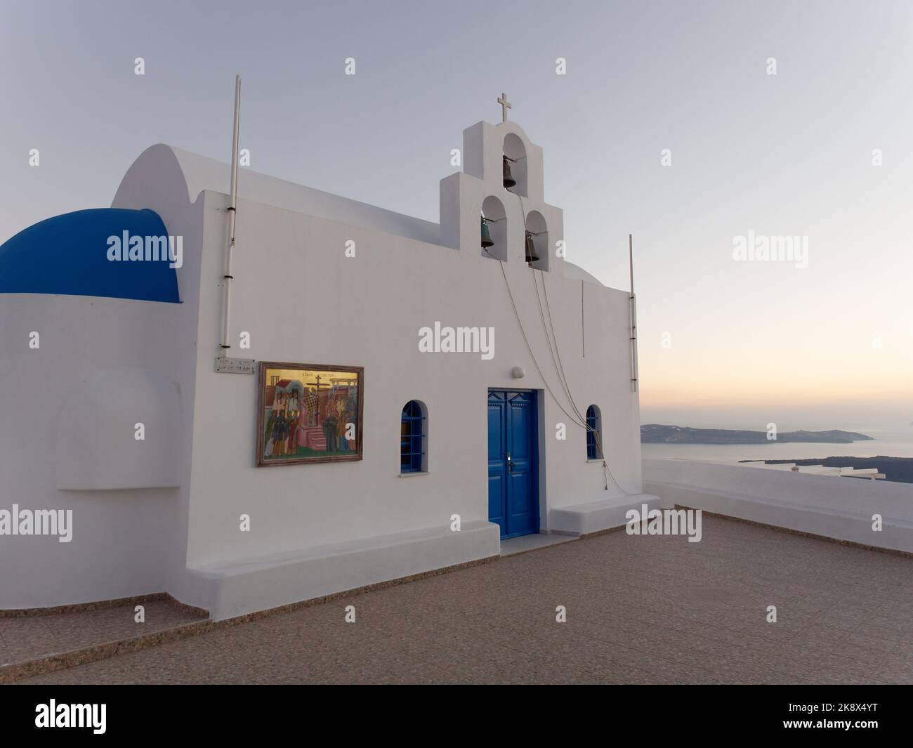 Chiesa bianca e blu al tramonto sull'isola greca delle Cicladi di Santorini. Foto Stock