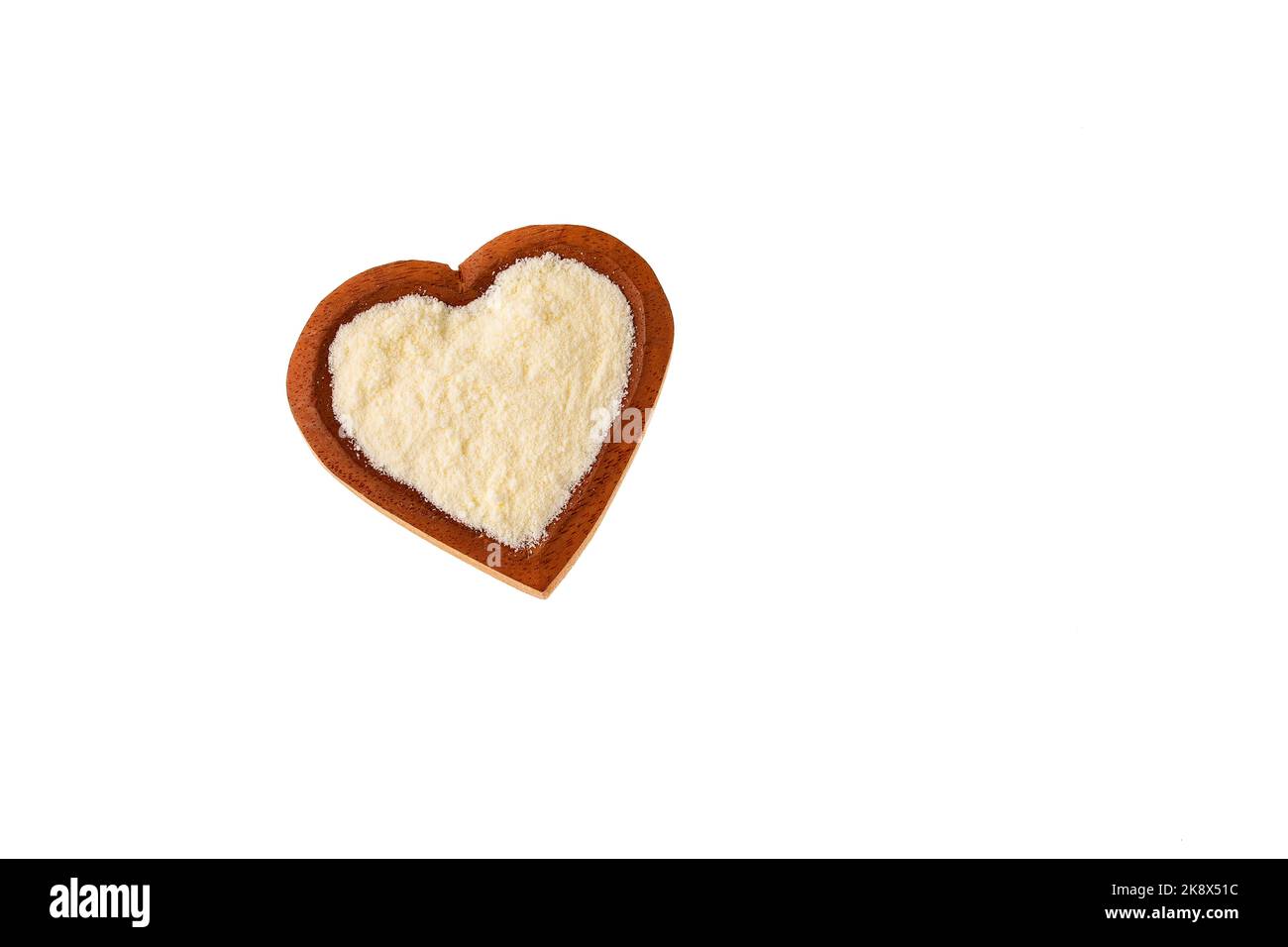 Latte in polvere o disidratato nel recipiente a forma di cuore Foto Stock