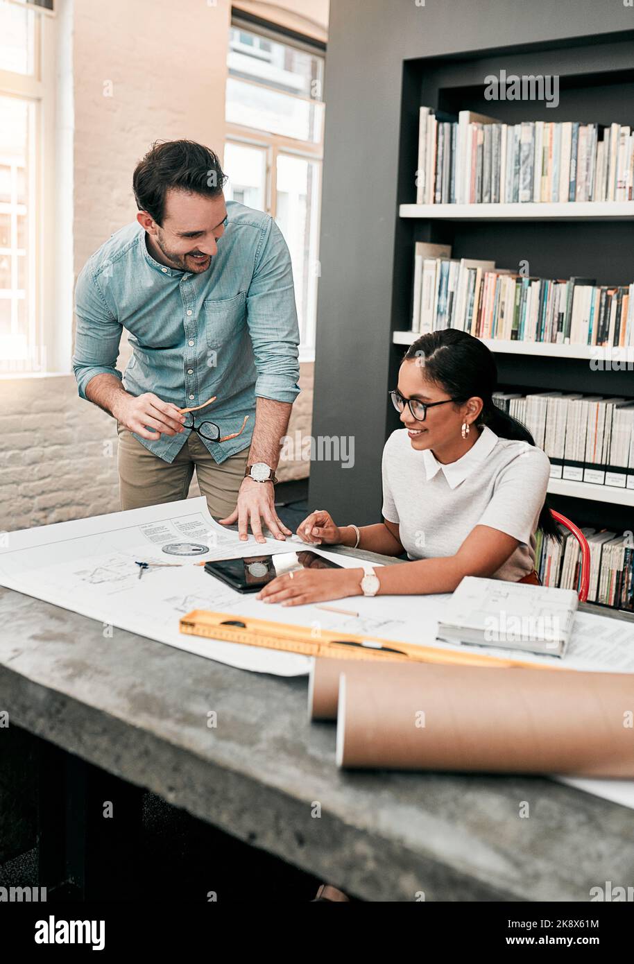 I progettisti possono ottenere idee straordinarie online. Due aspiranti giovani architetti utilizzano un tablet digitale mentre lavorano insieme in un ufficio moderno. Foto Stock